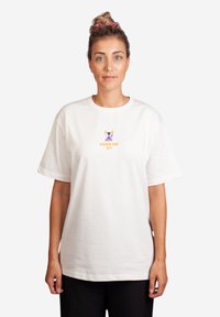 Weißes Baumwoll-T-Shirt mit kurzen Ärmeln und Rundhalsausschnitt. Mit einem bunten Hundemotiv und dem Text "LAZY AS" darunter.