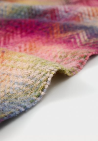 Uld tæppe med sildbenmønster, prydet med livlige farver som pink, grøn og blå; blød tekstur med en foldet kant.