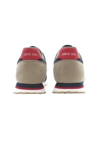 Zapatillas deportivas en azul marino y beige con parte superior de ante y malla, detalles en rojo en el talón y la inscripción "DESDE 1890" en el talón.