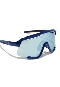 Plave prevelike sunčane naočale s elegantnim plastičnim okvirom i svijetloplavim lećama. Imaju kutne dizajnerske elemente i kontrastne crne vrhove okvira.