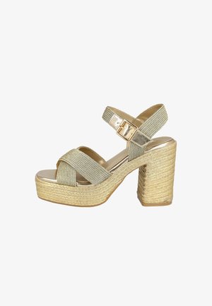 Sandalias de plataforma espadrille en tono dorado con correas de tela trenzada, un tacón grueso y cierre de hebilla. Base de fibra natural texturizada.