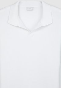 Weißes Poloshirt aus geripptem Baumwollstoff, mit einem klassischen Kragen, einer Dreiknopf-Leiste und einem Etikett mit der Aufschrift "CALLIOPE" nahe dem Kragen.