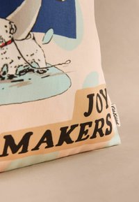 Bavlnená taška s karikatúrou psa špliechajúceho vo vode. Text znie "MAKERI RADOSŤI." Pozadie v pastelových farbách s texturovaným povrchom.