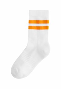 Calzino bianco in cotone con texture a coste, con due strisce orizzontali arancioni vicino alla parte superiore. Design atletico classico, lunghezza alla caviglia.