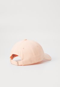 Roze baseballpet van stof, met een gebogen klep, stiksels, ventilatiegaten en een verstelbare strap aan de achterkant.