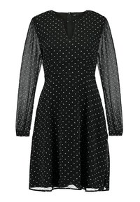 Robe noire avec de longues manches transparentes, un col rond et de subtils pois blancs. Jupe évasée avec une fermeture éclair dans le dos.
