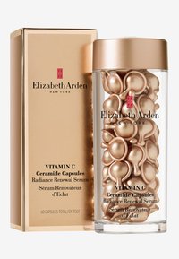 Gyllene cylindrisk behållare med genomskinliga sidor som innehåller flera gyllene ceramidkapslar. Lådan har "Elizabeth Arden"-logotypen.