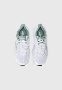 Weiße Sportschuhe mit Mesh-Obermaterial, grünen Akzenten und einer gepolsterten Sohle. Mit Schnürsenkeln und Branding auf der Zunge und an den Seiten.