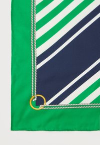 Γωνία υφάσματος με ρίγες σε πράσινο και ναυτικό μπλε, με λευκή περίμετρο από σχοινί και μικρό χρυσό δακτύλιο σε λευκό φόντο.