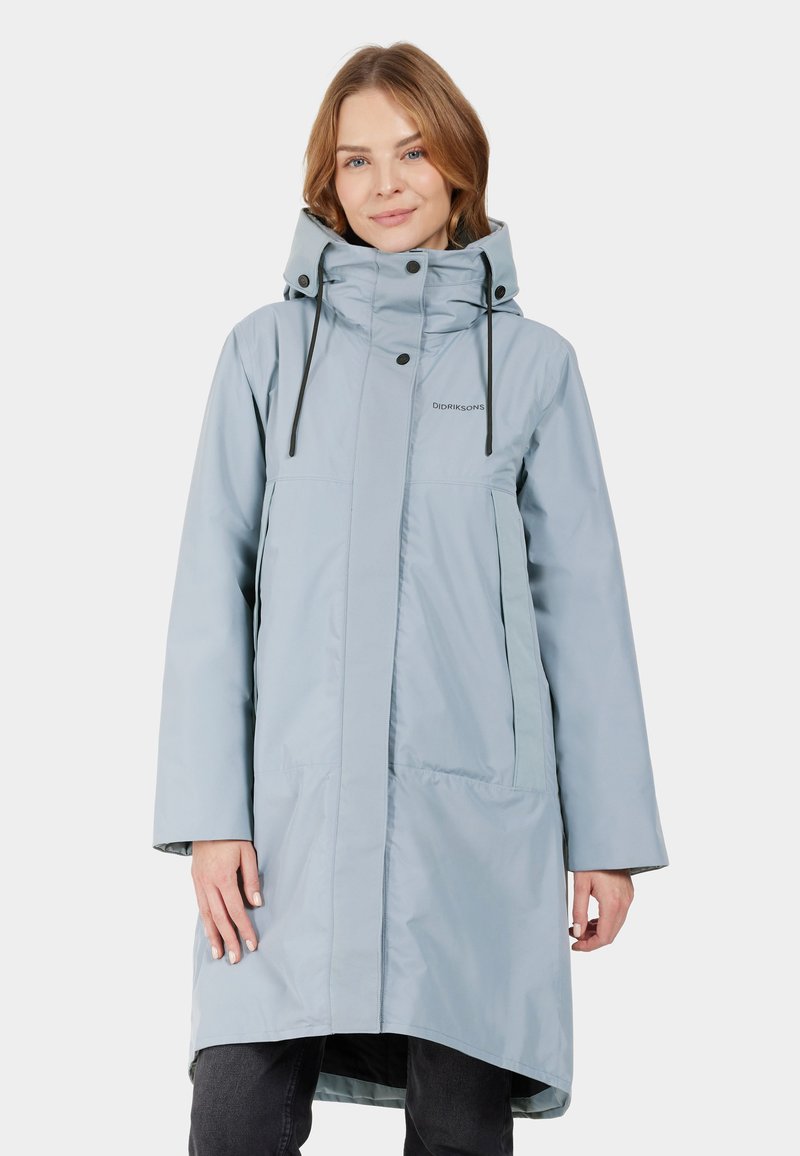 Helles blaues wasserdichtes Jacket mit hohem Kragen, verstellbarem Kapuzen und schwarzen Zugbändern. Verfügt über eine gerade Passform und zwei Seitentaschen.