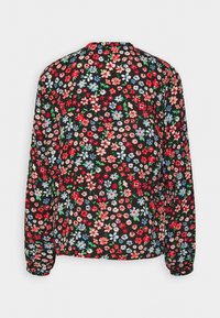 Blouse fleurie à manches longues avec un fond noir orné de fleurs rouges, roses et bleues, col arrondi et manches froncées aux poignets.