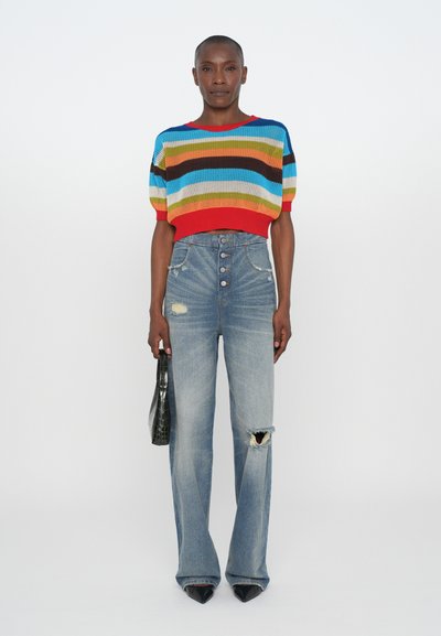 Colorful striped knitted sweater with short sleeves, paired with high-waisted light blue flared jeans featuring distressed details, and black heels.
