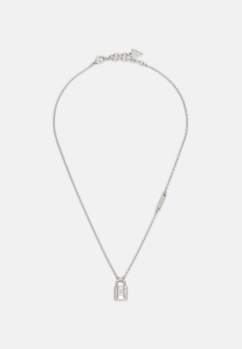 Collier chaîne en argent avec un petit pendentif cadenas présentant des détails décoratifs sur un fond blanc uni.