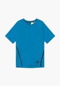 Camiseta deportiva azul hecha de tela sintética, con mangas cortas, un cuello redondo y detalles negros a lo largo de los lados.
