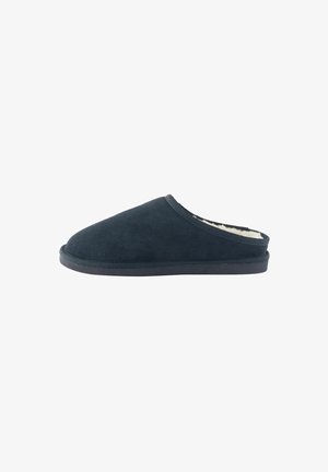 Sötétkék velúr, slip-on papucs, lekerekített orral és puha, bolyhos béléssel, lapos talppal és varrott szélein.