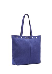 Niebieska zamszowa torba na ramię z dwoma uchwytami i sześcioma srebrnymi okrągłymi ćwiekami wzdłuż górnej krawędzi na białym tle.