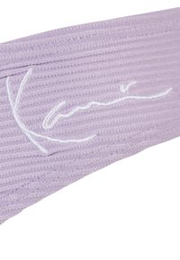 Lila bordázott anyagból készült fejpánt, fehér hímzett logóval. Az anyag texturált felületű, enyhe rugalmassággal.