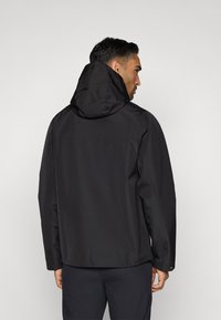 Must värvi veekindel jakk kapuutsiga, millel on sile tekstuur, sirge lõige ja tagaõmblused. Minimalistlik disain ilma nähtavate logodeta.