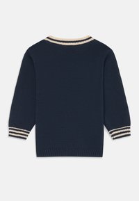 Pull en tricot bleu marine avec un col ras du cou, mettant en avant des accents rayés en crème et bleu marine contrastants aux poignets et au col. Design à coupe régulière.