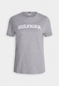 Camiseta de algodón gris con cuello redondo, mangas cortas y texto blanco "HILFIGER" en el pecho. Textura suave, corte casual.