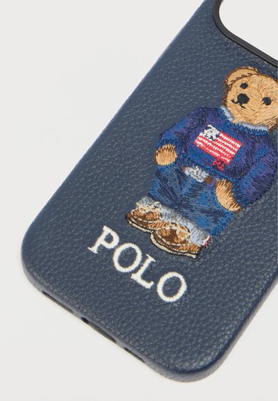 Θήκη τηλεφώνου Navy με υφή, με κεντημένη αρκούδα που φορά τζιν, πουλόβερ με αμερικανική σημαία και το κείμενο "POLO" από κάτω.