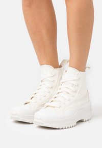 Vita högskurna sneakers i canvas, med en strukturerad yta, rund tå och en tjock, räfflad gummisula.