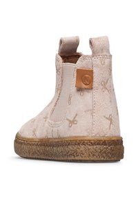 Bottine en daim rose avec des côtés élastiques, accents de motif doré et semelle en caoutchouc texturée marron. Présente une étiquette logo sur le talon.