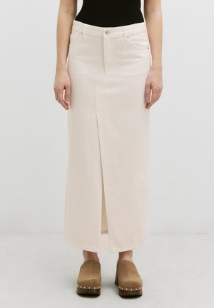 Jupe maxi en denim beige avec une fente sur le devant, des poches et des passants de ceinture, assortie à des sabots à plateforme beige avec des accents métalliques.