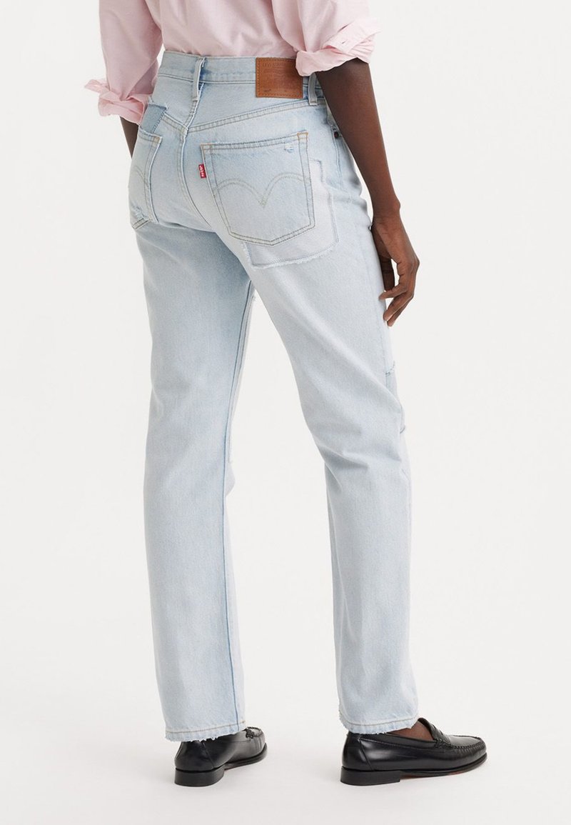 Jeans in denim azzurro chiaro con taglio dritto, dotati di tasche applicate, un'etichetta in pelle sul retro e dettagli di cucitura discreti.