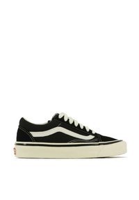 Sneaker nera in tela a basso profilo con lacci bianchi e una distintiva striscia bianca laterale. Presenta cuciture a contrasto e una suola in gomma crema.