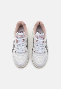 Zapatillas de cuero blancas con detalles en rosa, caja de dedos perforada y rayas laterales grises. Presentan cordones blancos y un cuello acolchado para mayor comodidad.