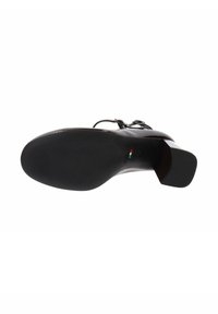 Zwarte leren hakschaduw met een ronde neus en een brede blokhak. Gladde textuur met minimale accenten en een subtiel logo op de zool.