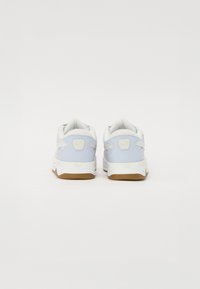 Baskets de couleur bleu clair avec des accents blancs, semelle en caoutchouc, col rembourré, détail du logo sur le talon et dessus texturé pour la respirabilité.