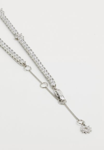 Silver-tonad armband med flera klara rhinestones, en kräfta clasp och en dekorativ snöflinge charm på ett delikat kedja.