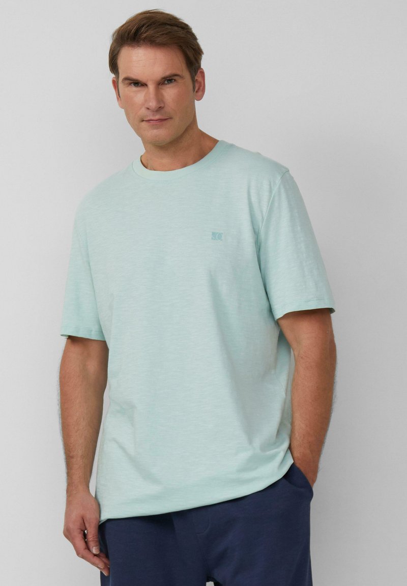 Jasno miętowy t-shirt z krótkim rękawem wykonany z miękkiego materiału, z okrągłym dekoltem i małym logo na lewej piersi.