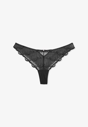 Black lace thong featuring scalloped edges, transparent mesh with embroidered details, and a solid fabric back. Includes a small center bow accent.
