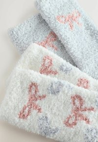 Sada troch nadýchaných uterákov v svetlosivej a bielej farbe. Na mäkkom, textúrovanom povrchu sa nachádzajú vzory ružových a sivých mašlí.