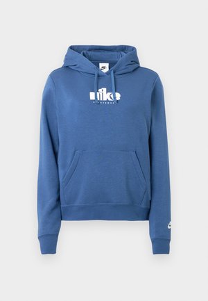 Zils džemperis ar kapuci, priekšpusē kangaru kabatu, auklu kapucē un baltu Nike logotipu krūšu daļā un piedurknē. Izgatavots no mīksta, teksturēta auduma.