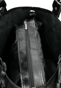 Interno di una borsa a tracolla nera in pelle, con una morbida fodera nera, compartimento con zip e una superficie lucida nel corpo principale.