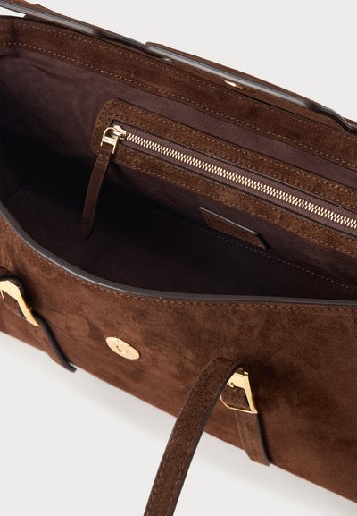 Καφέ σουέντ τσάντα χειρός με χρυσή αγκράφα και κούμπωμα με κλικ, με εσωτερική τσέπη με φερμουάρ και δερμάτινη ταινία τραβήγματος.