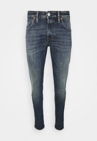 Dunkelblaue Jeans aus Denim im Slim-Fit mit fünf Taschen, Gürtelschlaufen und Knopfverschluss. Mit Used-Effekten entlang der Beine.
