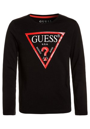 Chemise noire à manches longues avec un logo triangle rouge comportant le mot GUESS, un point d'interrogation rouge et le texte "U.S.A. Washed Jeans."