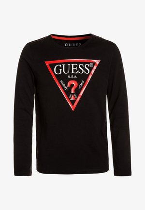 Sort langærmet skjorte med en rød trekantet logo med ordet GUESS, et rødt spørgsmålstegn og tekst "U.S.A. Washed Jeans."