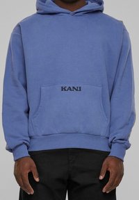Blå sweatshirt med huva, som har en framficka och svart "KANI"-text. Mjukt tyg och ribbade ärmslut samt fåll ger en bekväm passform.