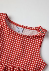 Punainen ja valkoinen ruudullinen mekko, puuvillakangasta, ilman hihoja, pyöreä pääntie, yhdellä olalla napsautettava suljenta, volangiraita helmassa.