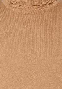 Ljusbrun polotröja gjord av ribbat tyg, med en kroppsnära passform och en jämn textur genom hela plagget.