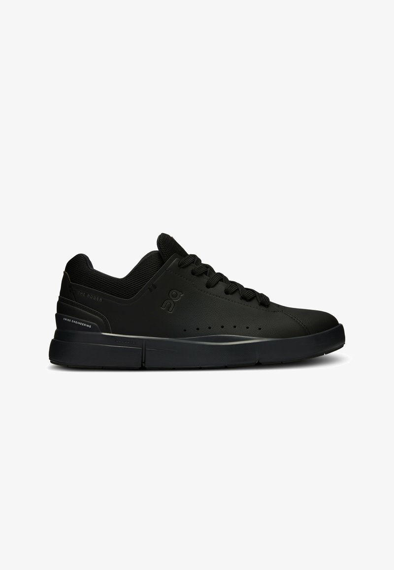 Chaussures de sport noires avec une tige en cuir lisse, des détails perforés et une semelle rembourrée ; avec des lacets ronds et un logo sur le côté.