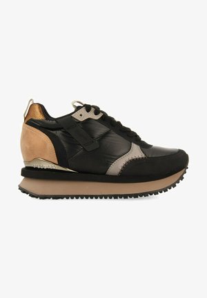 Sneaker nero e marrone con una finitura lucida, dettagli in camoscio e un dettaglio del tallone dorato. Presenta una suola texturizzata e cuciture in contrasto.