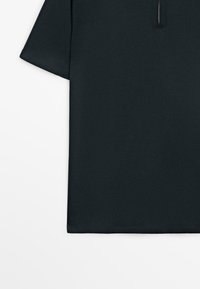 Czarna koszula z krótkim rękawem i krótkim zamkiem przy dekolcie, gładki wzór, pokazana z przodu na białym tle.