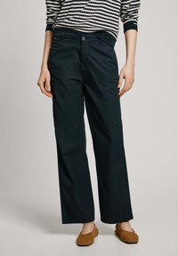 Pantalones de pierna ancha en color azul marino, fabricados con un tejido ligero y de textura suave. Cuentan con un cierre de botón y dos bolsillos frontales.